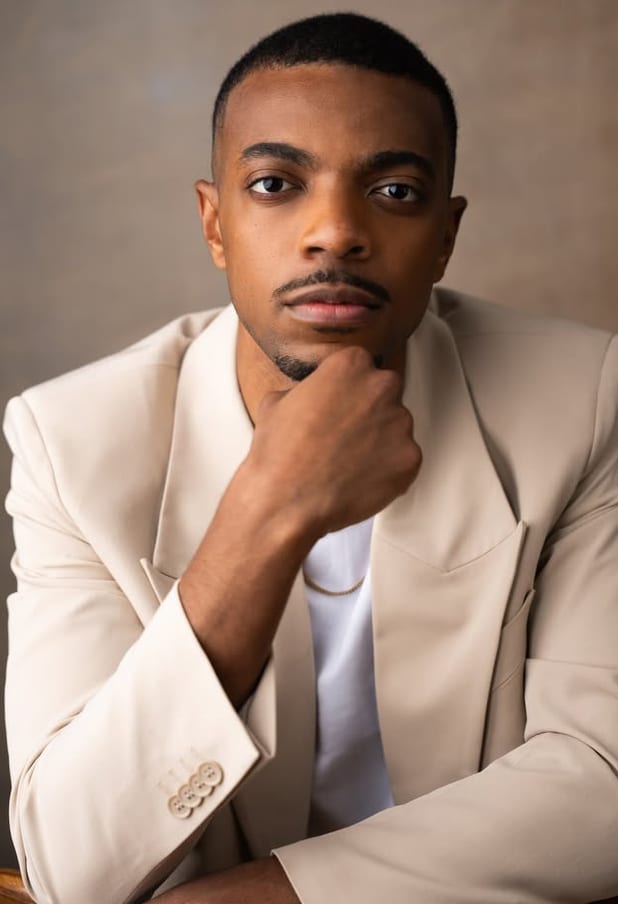 Destin Tucker seated, chin resting on his hand